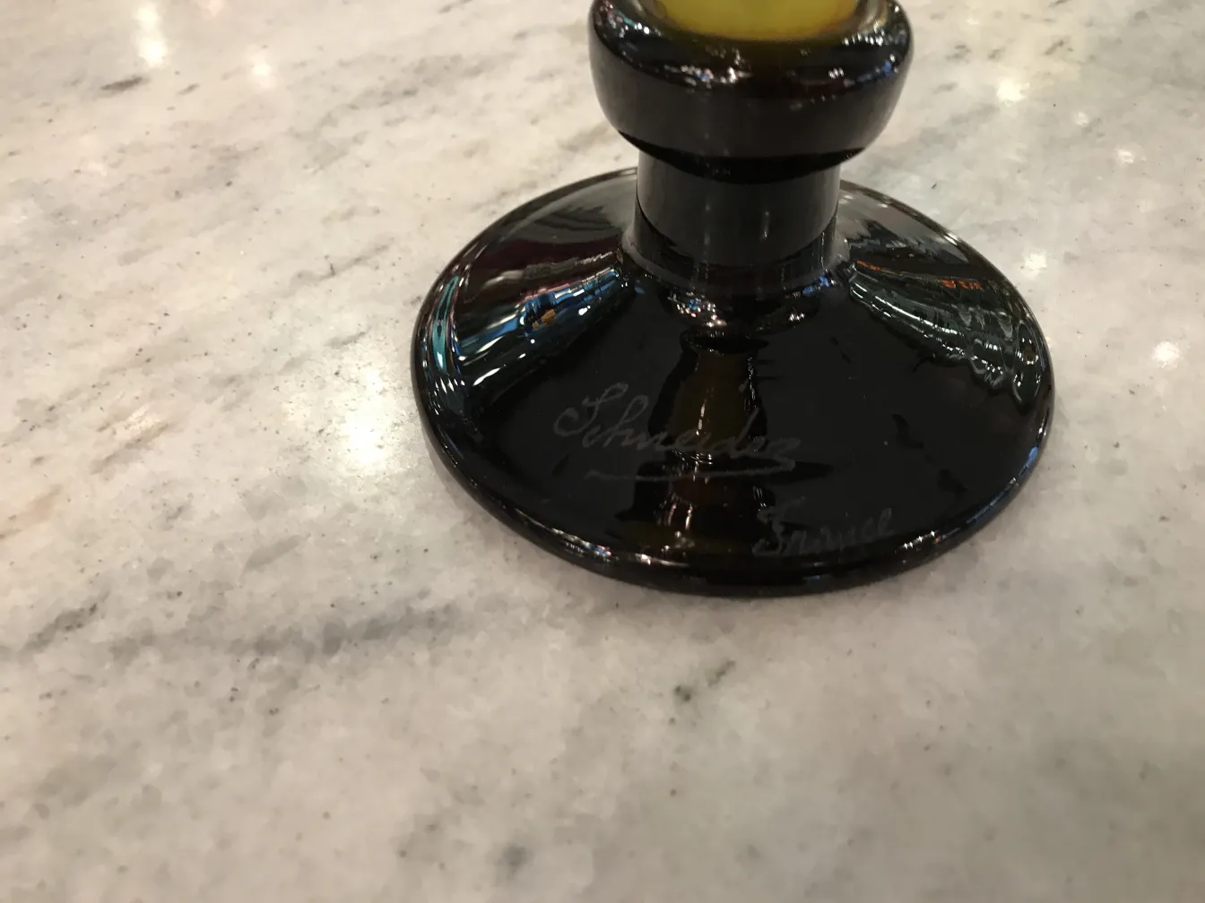 Vidrio firmado de la antigüedad con base negra Schneider, ambiente elegante.