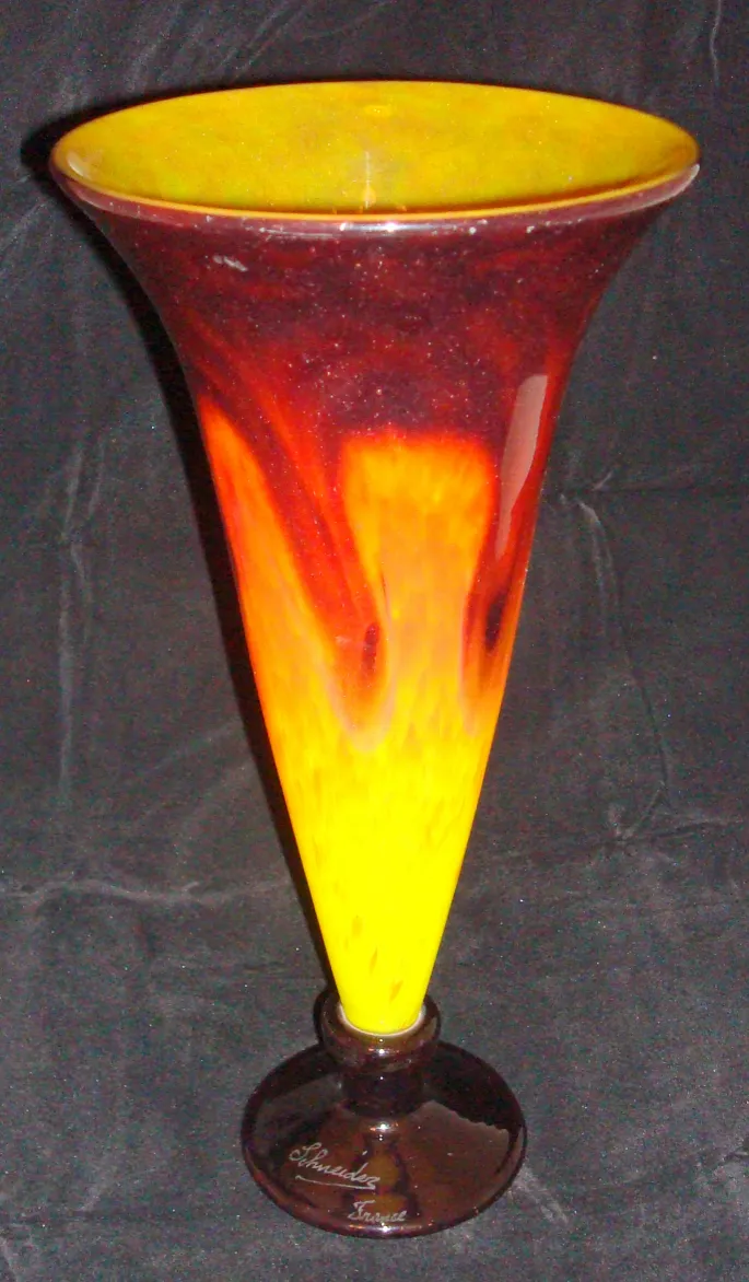 Signiertes Glas in rot-gelben Tönen mit Muster.