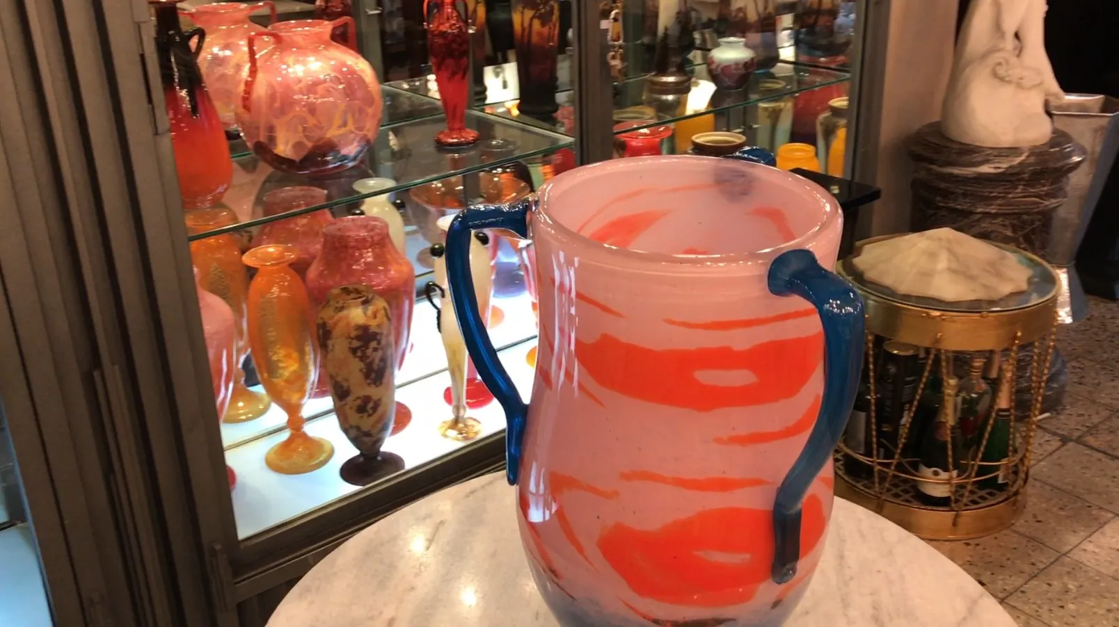 Vase en verre avec motif rose et bleu dans un cadre ancien.