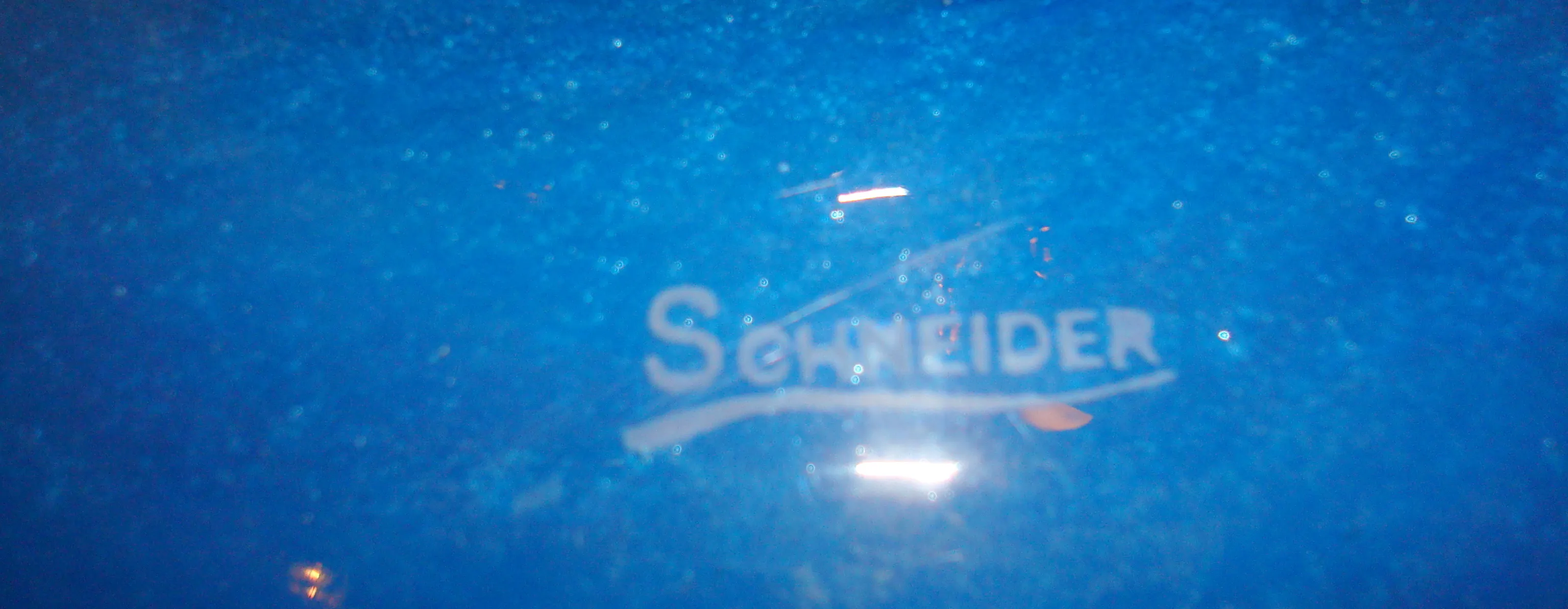vidro antigo com assinatura Schneider em fundo azul
