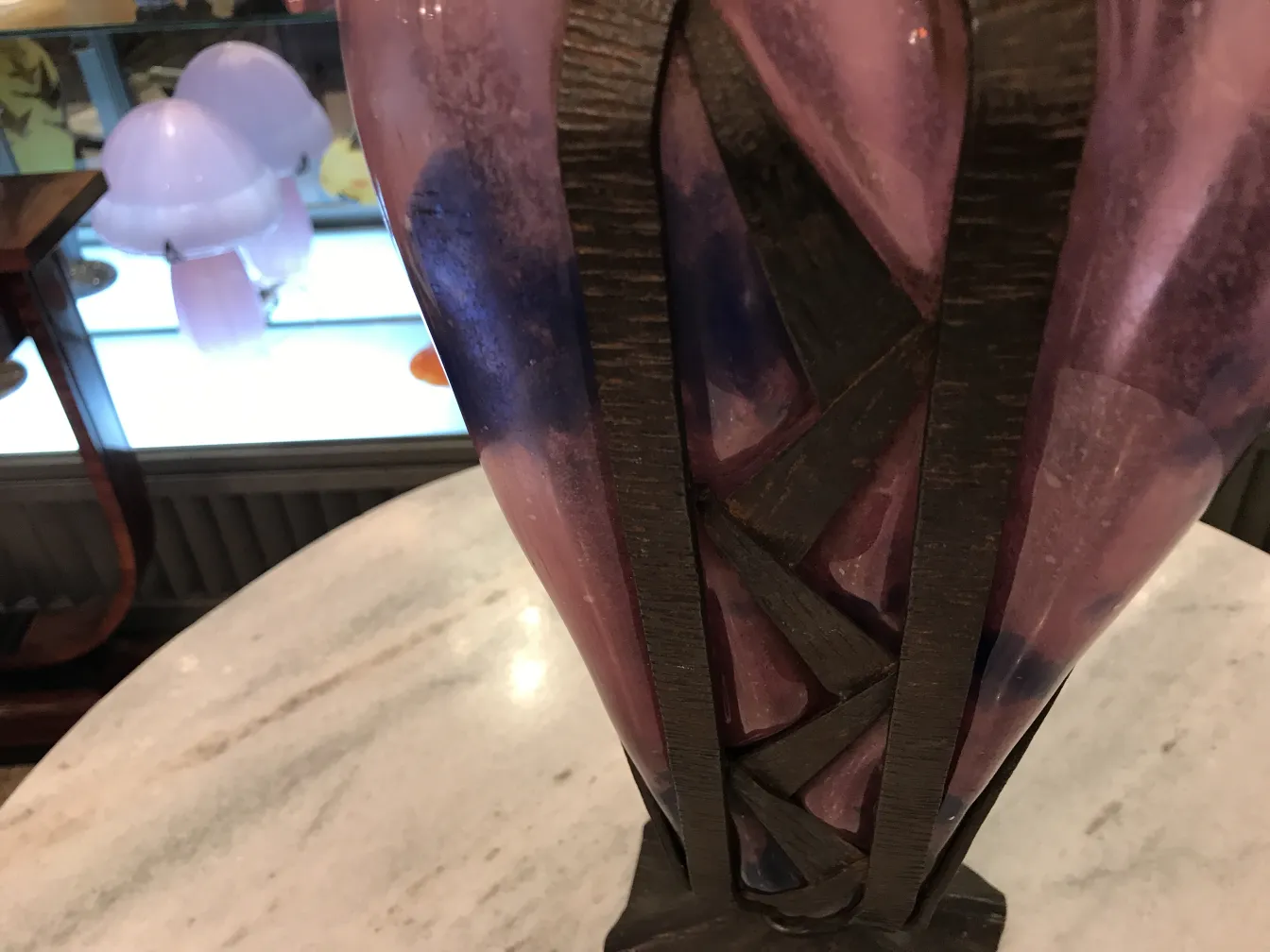 Vetro antico firmato da Schneider con design francese in tonalità di rosa e blu, sfondo di esposizione.