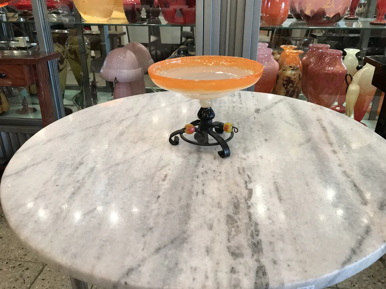 Verre avec base noire et accents colorés dans un cadre antique.