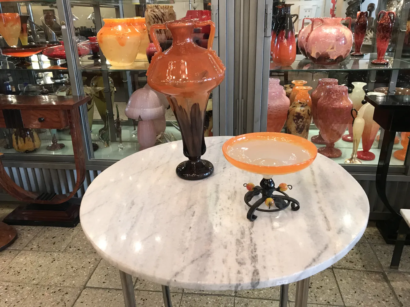 signed glass by schneider displayed with other antiques.