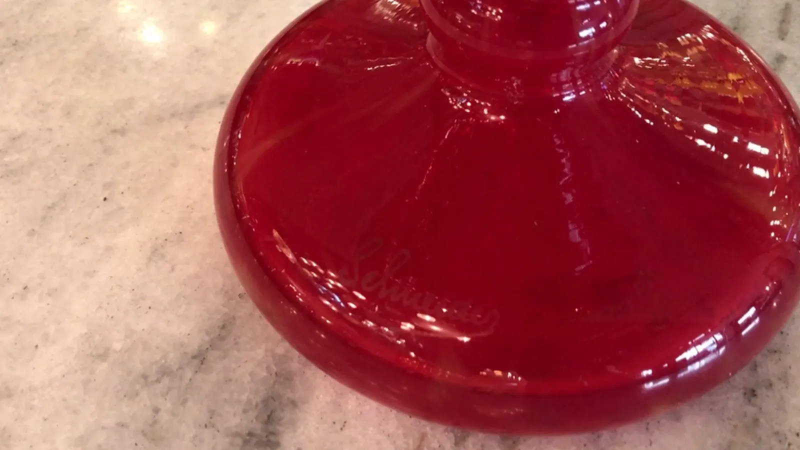 Antique signed glass with a red base, elegant setting.