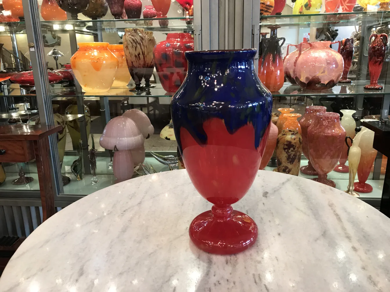 decorative antique signed glass in blue and red with other vases in the background