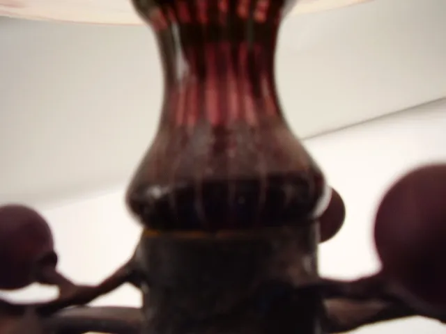 Vidro escuro com detalhes decorativos em forma de estrias.