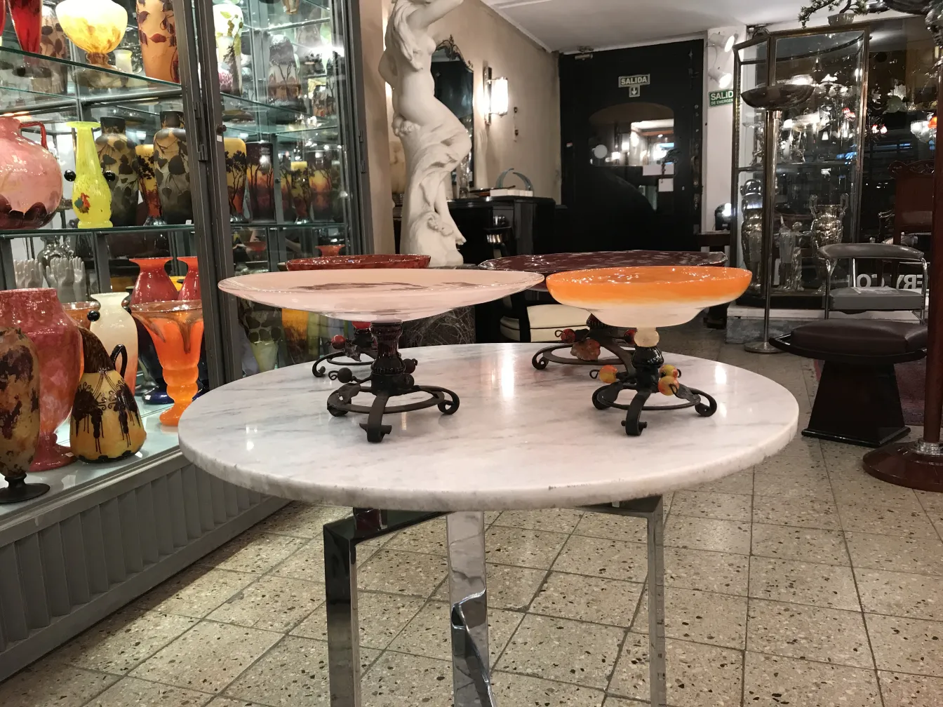 Antikes, signiertes Glas von Schneider, präsentiert auf einem dekorativen Sockel zwischen bunten Vasen.