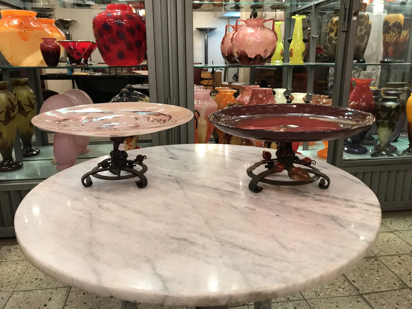 Antique signed glass plate by Schneider on a decorative pedestal.