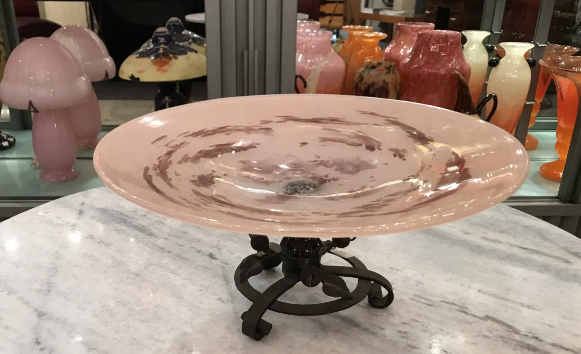 Prato decorativo de vidro assinado Schneider com base metálica, cores suaves.