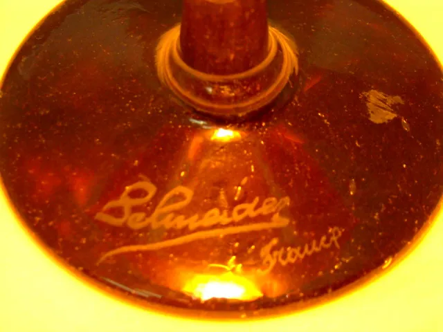 Vidrio firmado antiguo de Schneider con detalles visibles. Ambiente sofisticado.