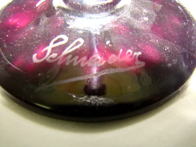 Detailed view of an antique signed glass by Schneider, featuring deep colors and an elegant design.
