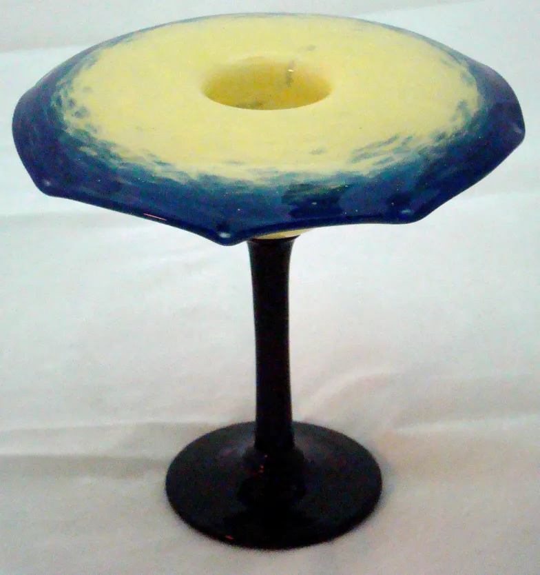 Signed glass in flower shape with black base and blue hues.
