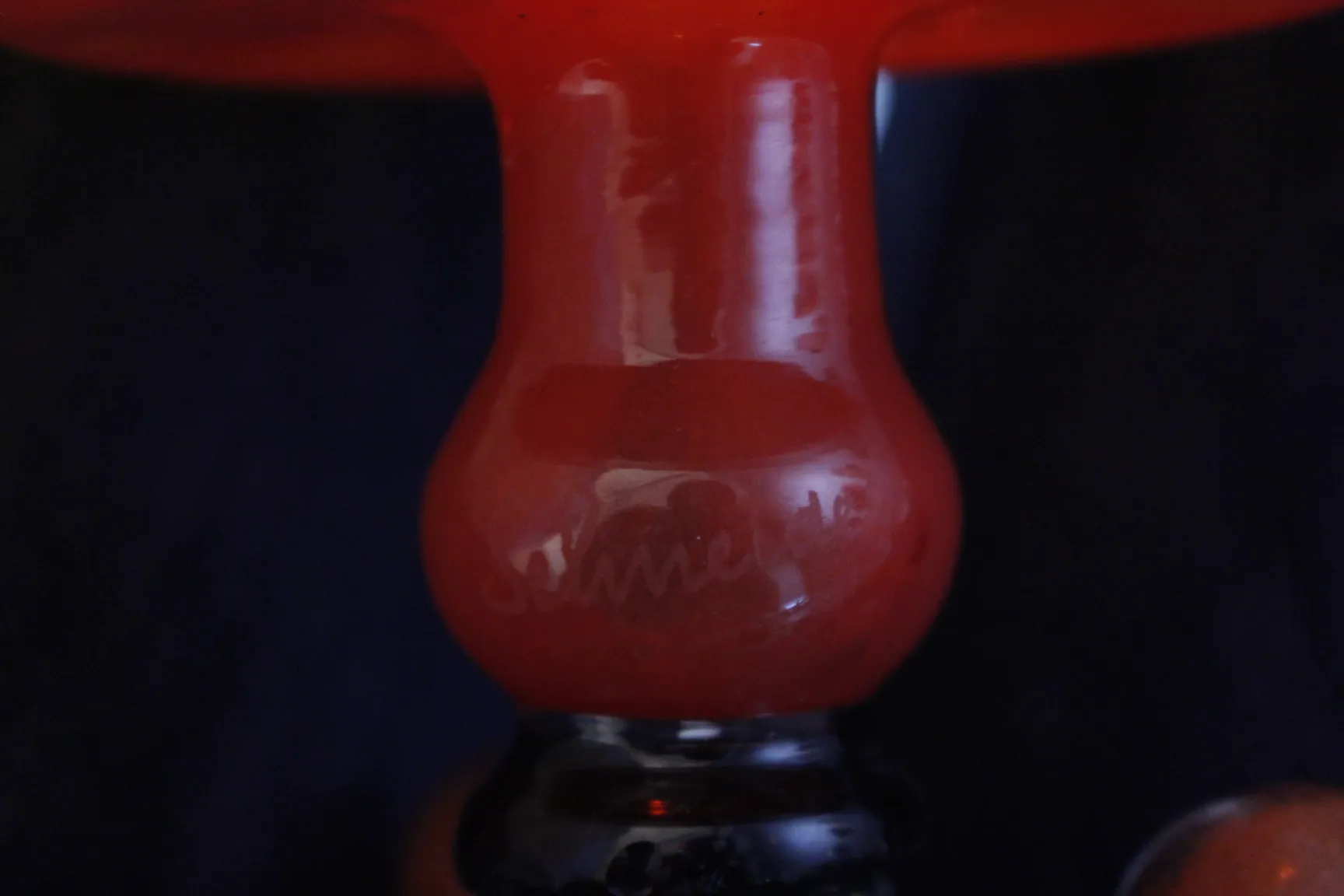 red signed glass, antique, featuring Schneider's signature, dark background