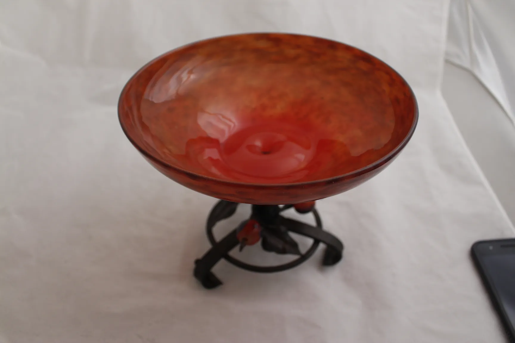 vidrio firmado de color rojo sobre soporte metálico negro