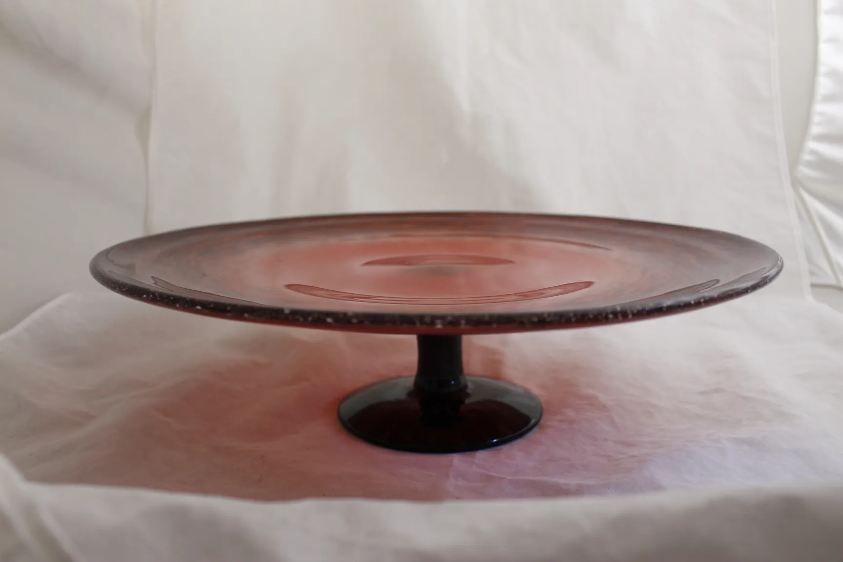 Verre ancien signé par Schneider en rouge, sur un socle sombre.