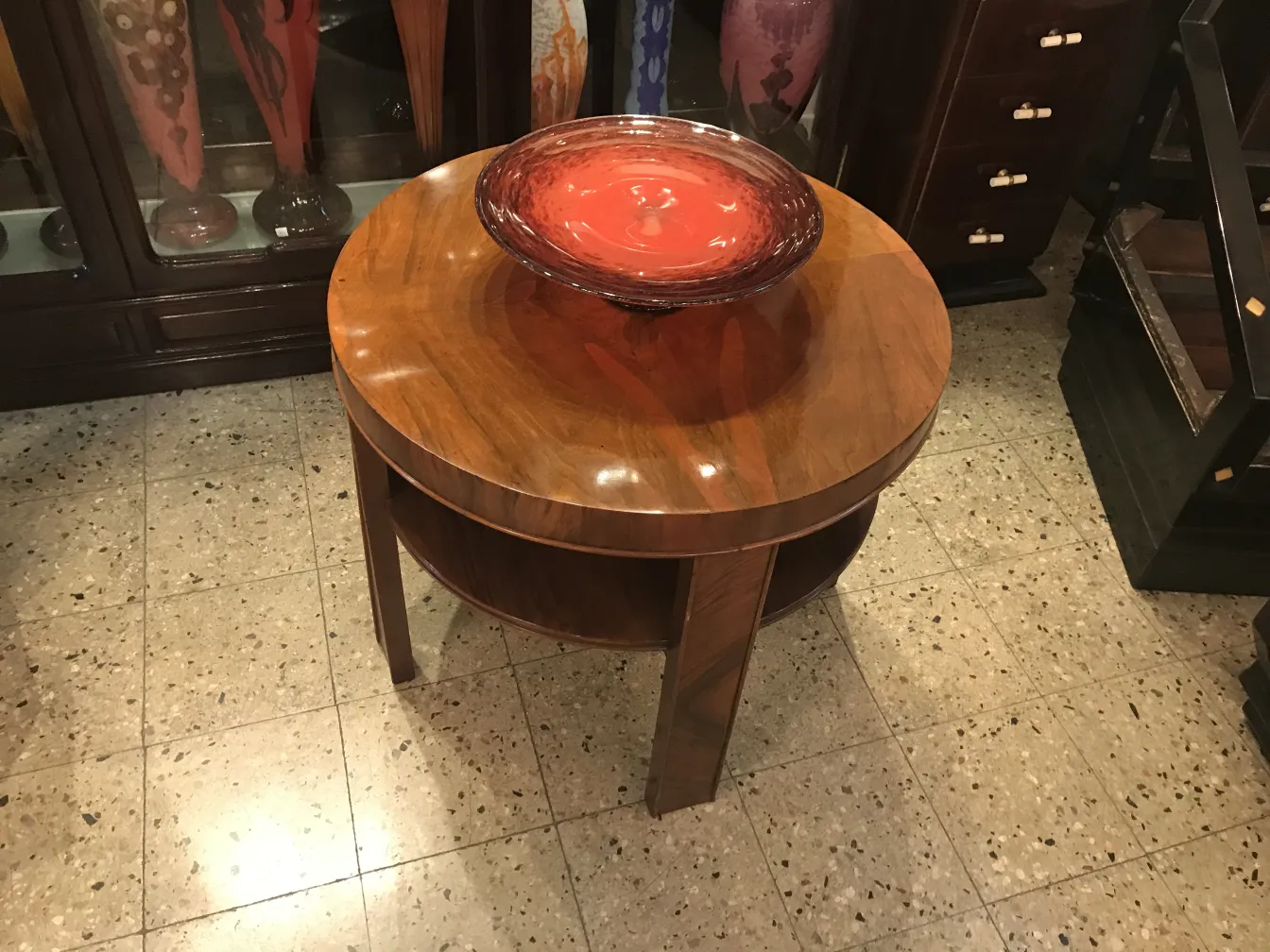 Round glass vessel with signature on wooden table
