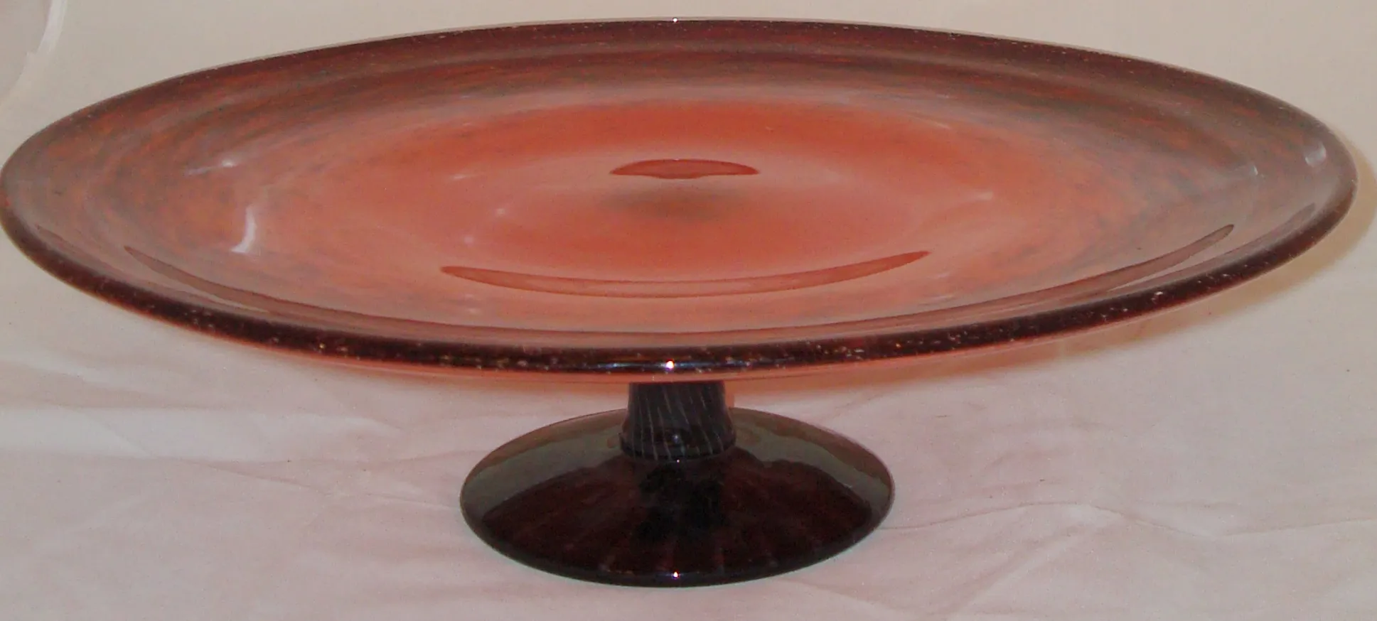 plato de vidrio firmado en tonos rosa y negro, fondo claro