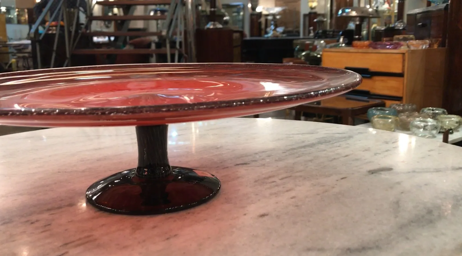 Seitenansicht eines signierten Glases (Schneider) auf Marmor, mit antikem Hintergrund.