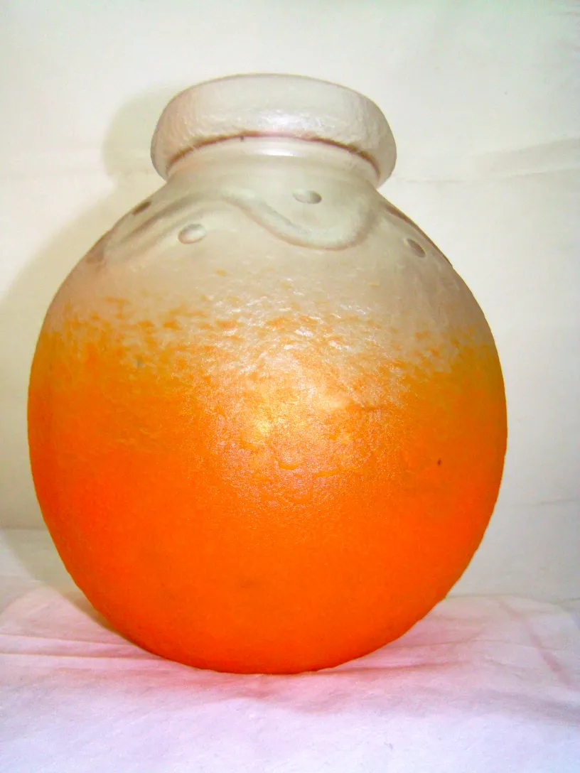 Round signed glass in orange and clear color.