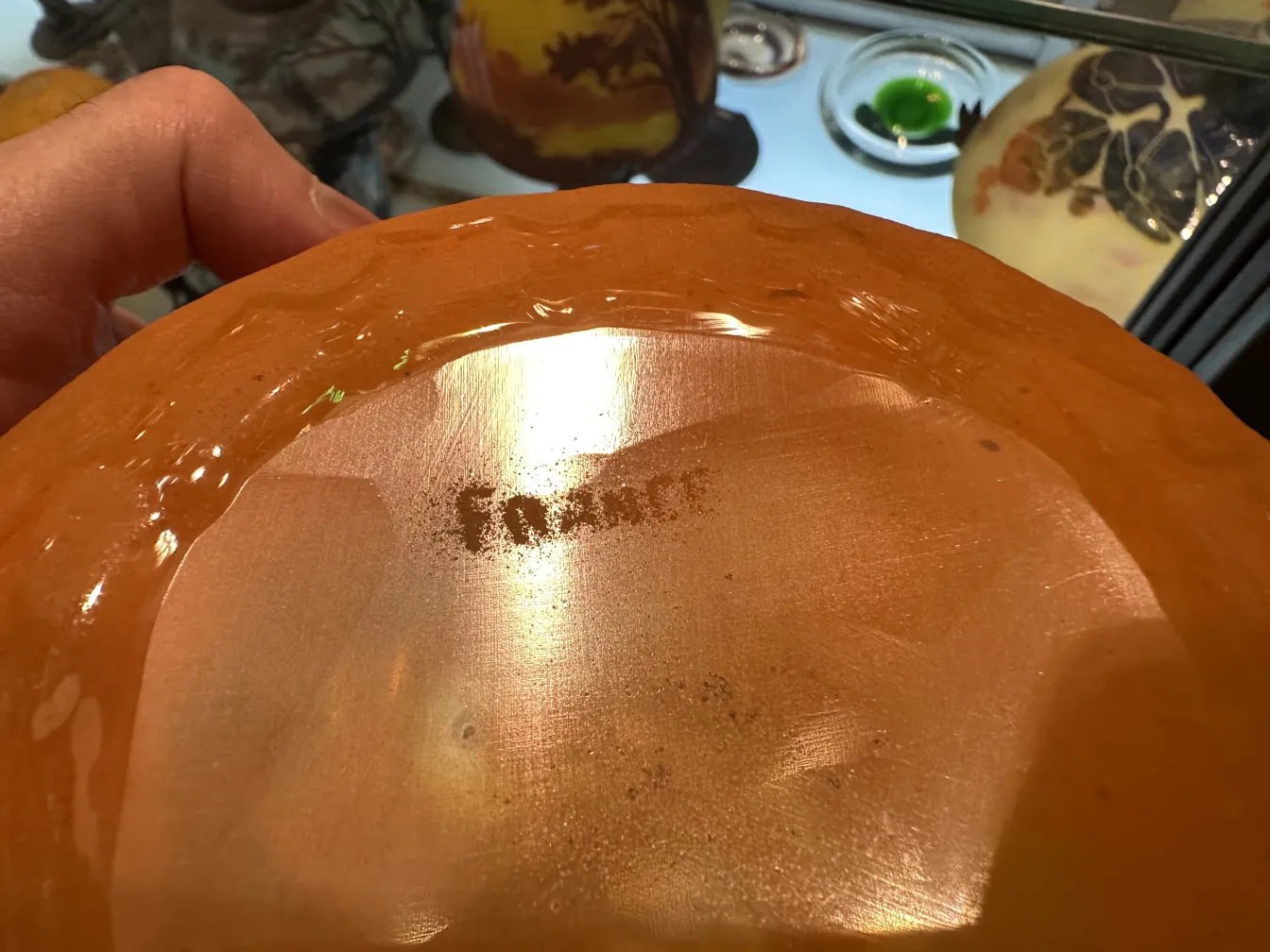 Vidro assinado de Schneider com detalhes antigos e ambiente decorativo.