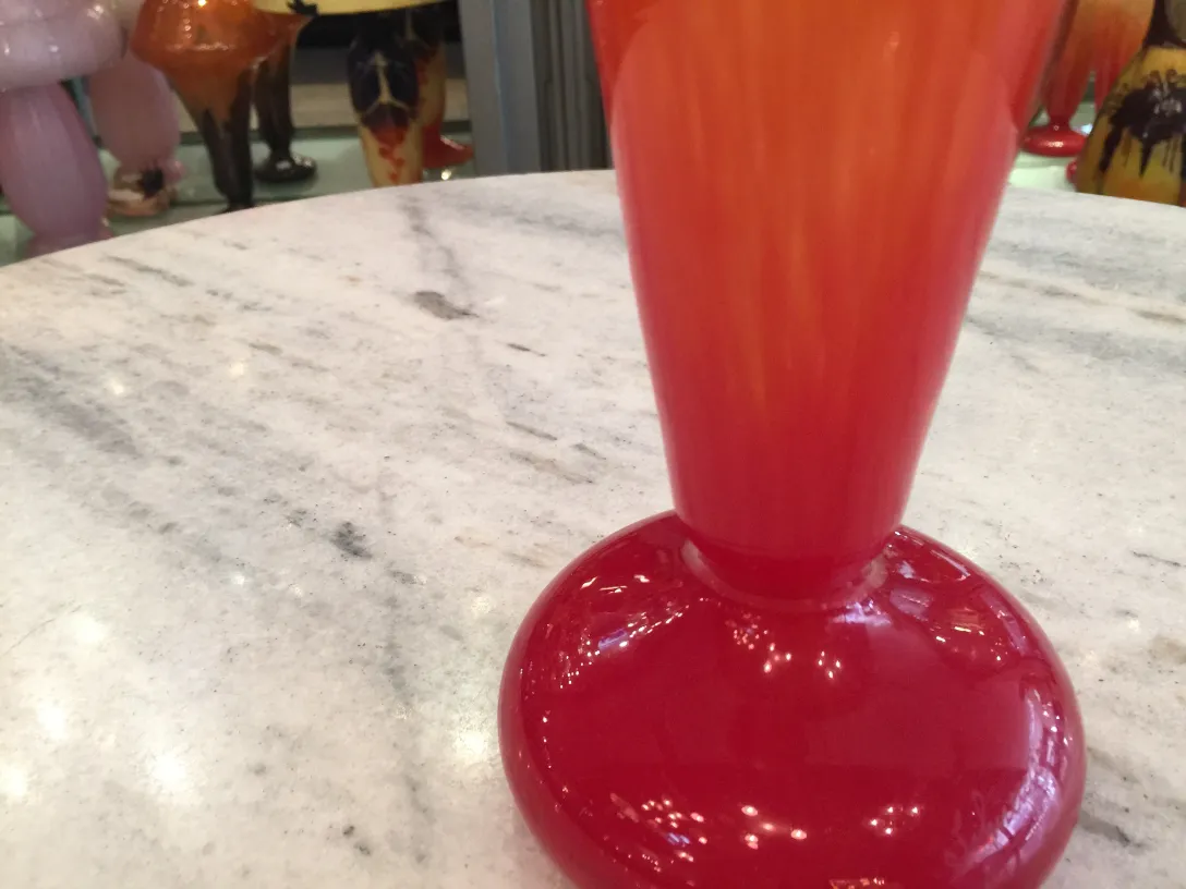 Vetro antico firmato Schneider, di colore arancione e rosso, in un ambiente elegante.