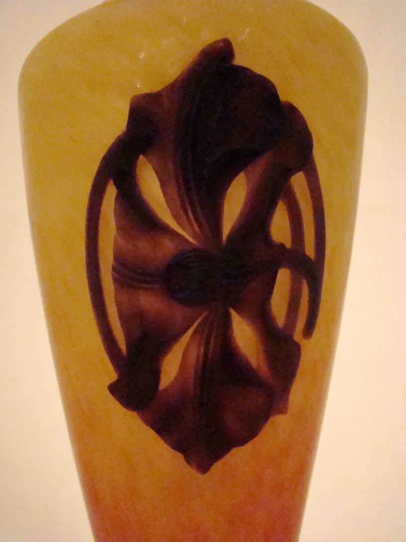 Vaso antigo com design em relevo escuro na frente, estilo floral