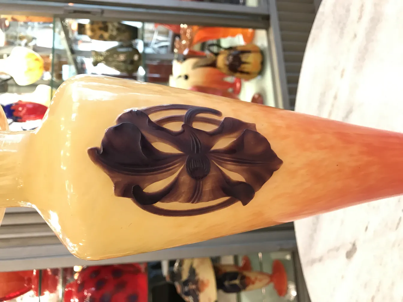 古董玻璃瓶，带有浮雕花卉设计和可见的签名。