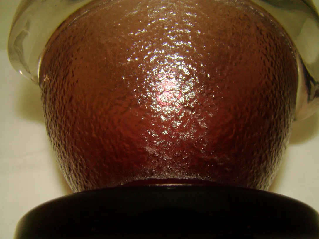 古董红色玻璃，具有质感，底部有签名。氛围柔和且明亮。