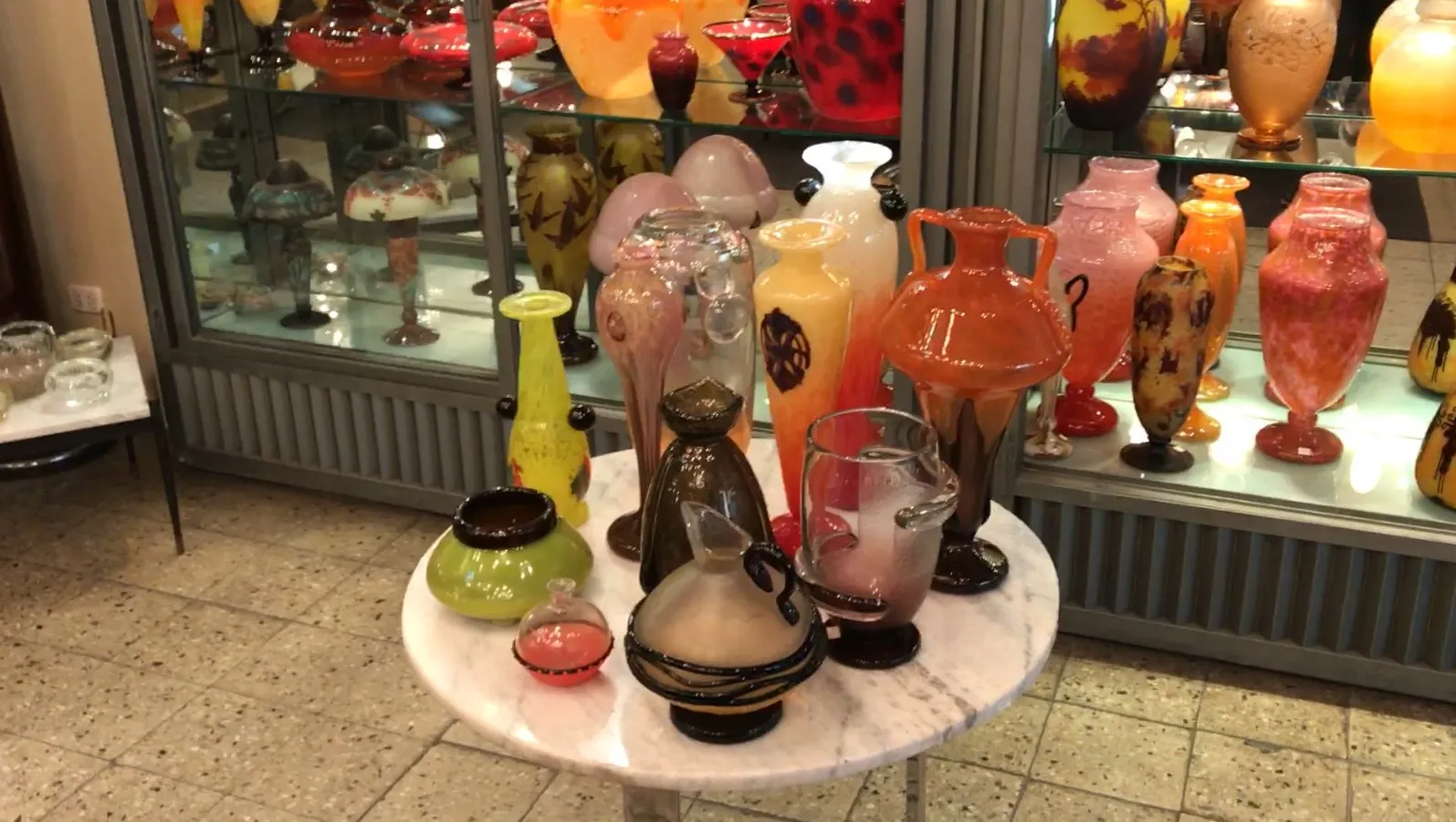 飾り棚に展示されているアンティークサイン入りグラス（シュナイダー）