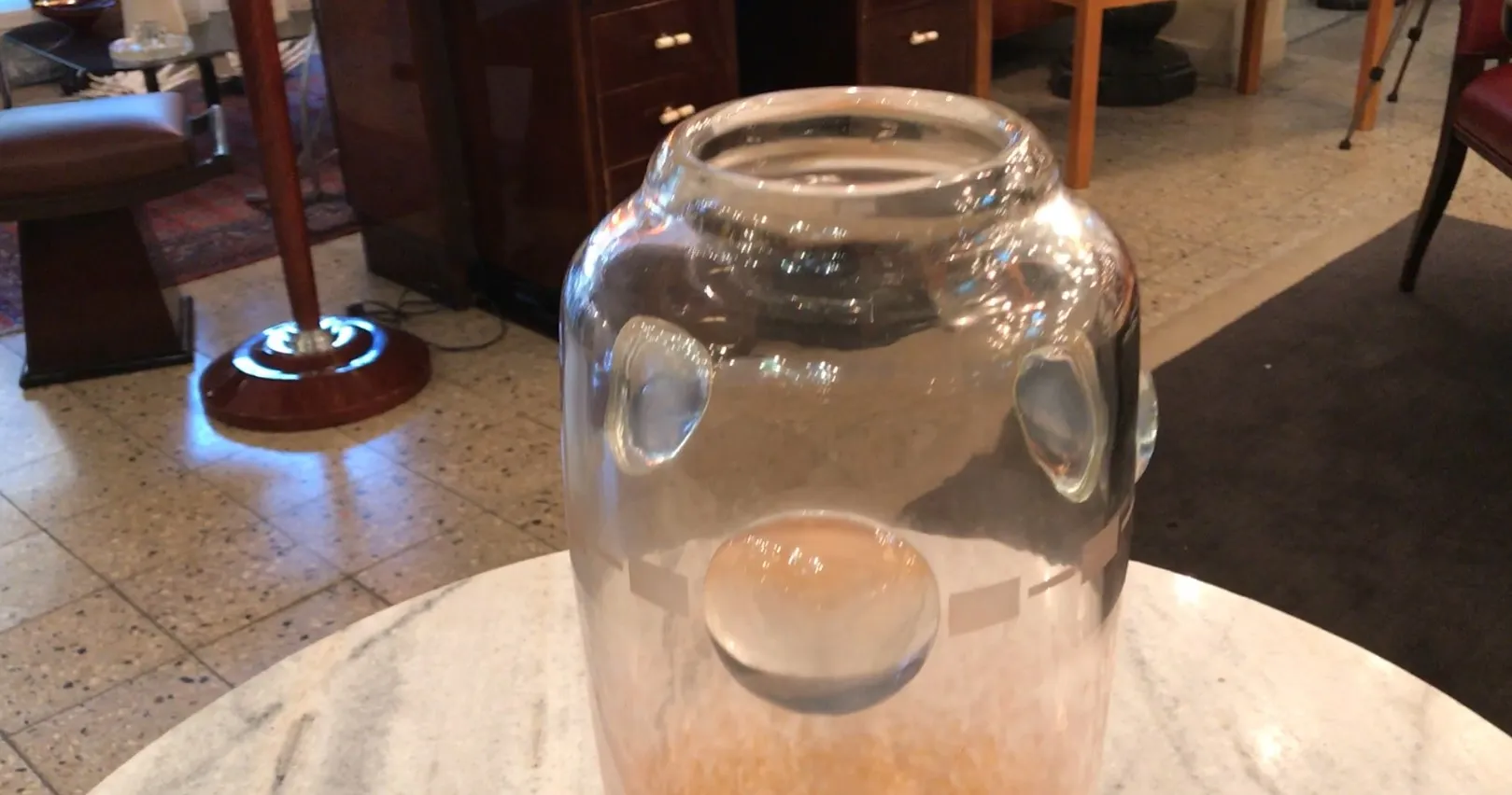 Antikes signiertes Glas von Schneider mit sichtbaren Details im Inneren, auf einem Tisch präsentiert.