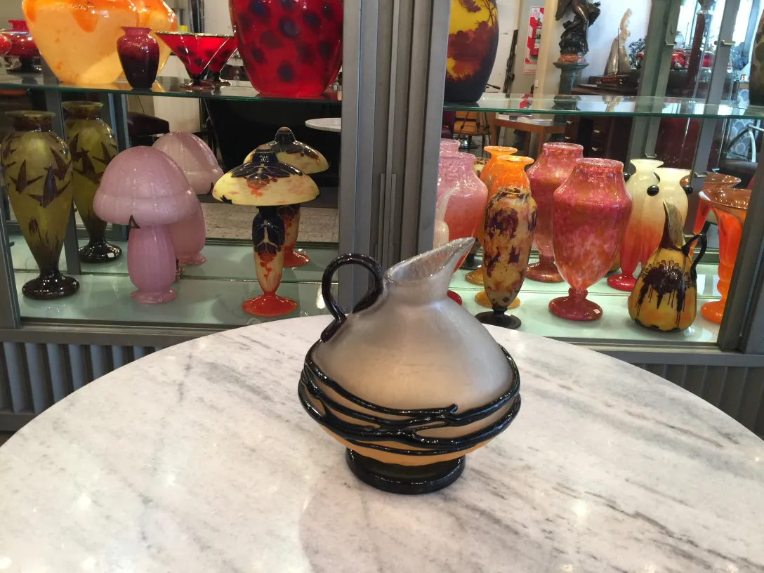 brocca di vetro con dettagli decorativi e forma elegante in un contesto di antiquariato