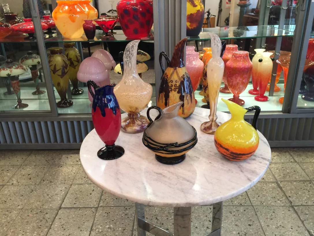 Sammlung von Antiquitäten, signiertes Glas Schneider in der Auslage.