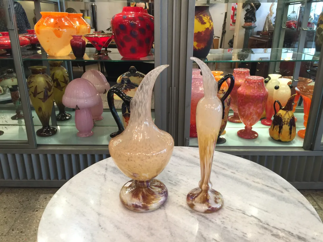 Zwei antike Krüge aus signiertem Glas von Schneider, elegant und farbenfroh, in einer Antiquitätenumgebung