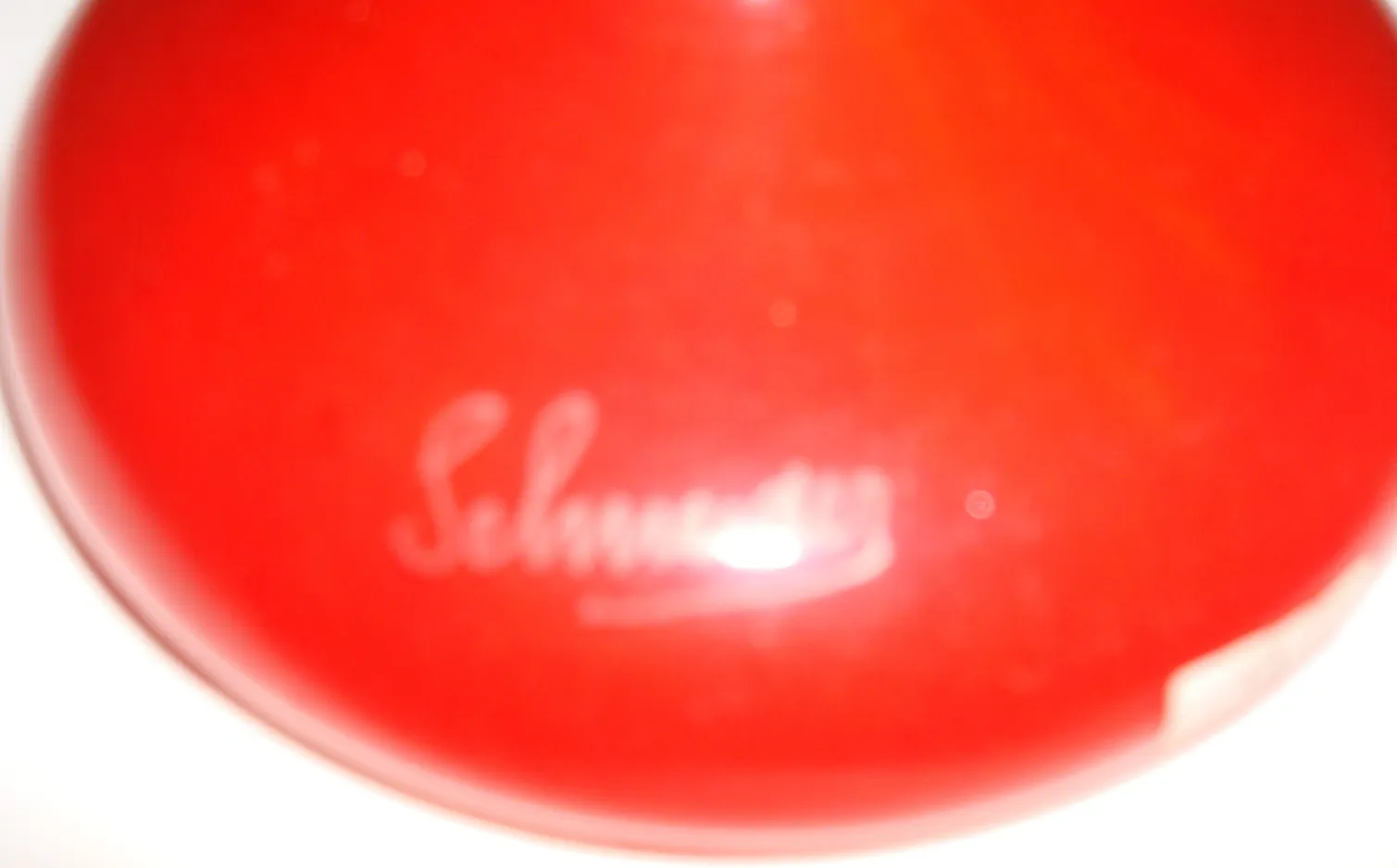 Rotes Glas mit sichtbarer Unterschrift von Schneider.