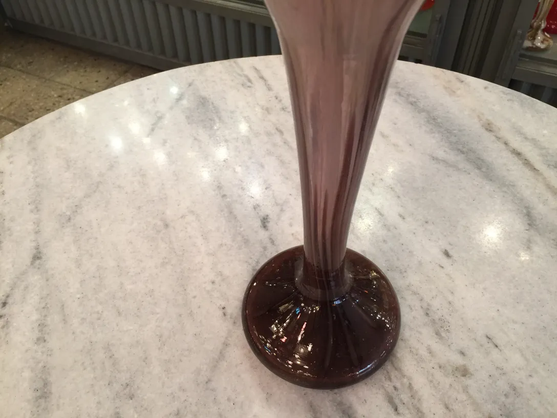 Glass signed antique Schneider in purple on pedestal with cream background.