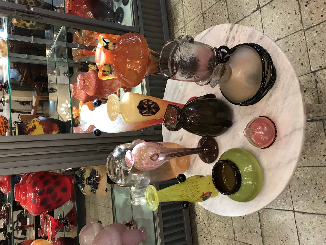 Conjunto de antigüedades en vitrina con vidrio firmado Schneider y otros objetos decorativos.