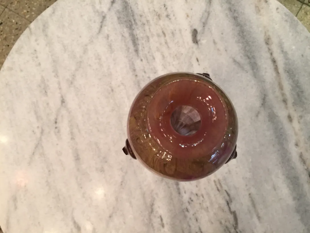 Signed glass with details in a marble setting.