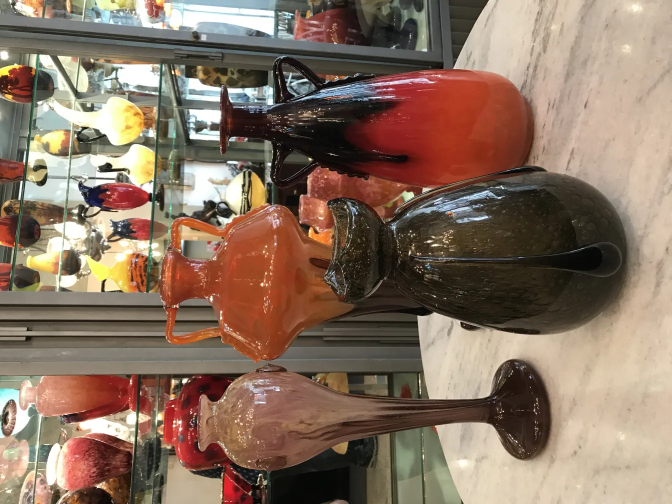 SIGNED GLASS Schneider featuring distinctive shapes in various colors on display