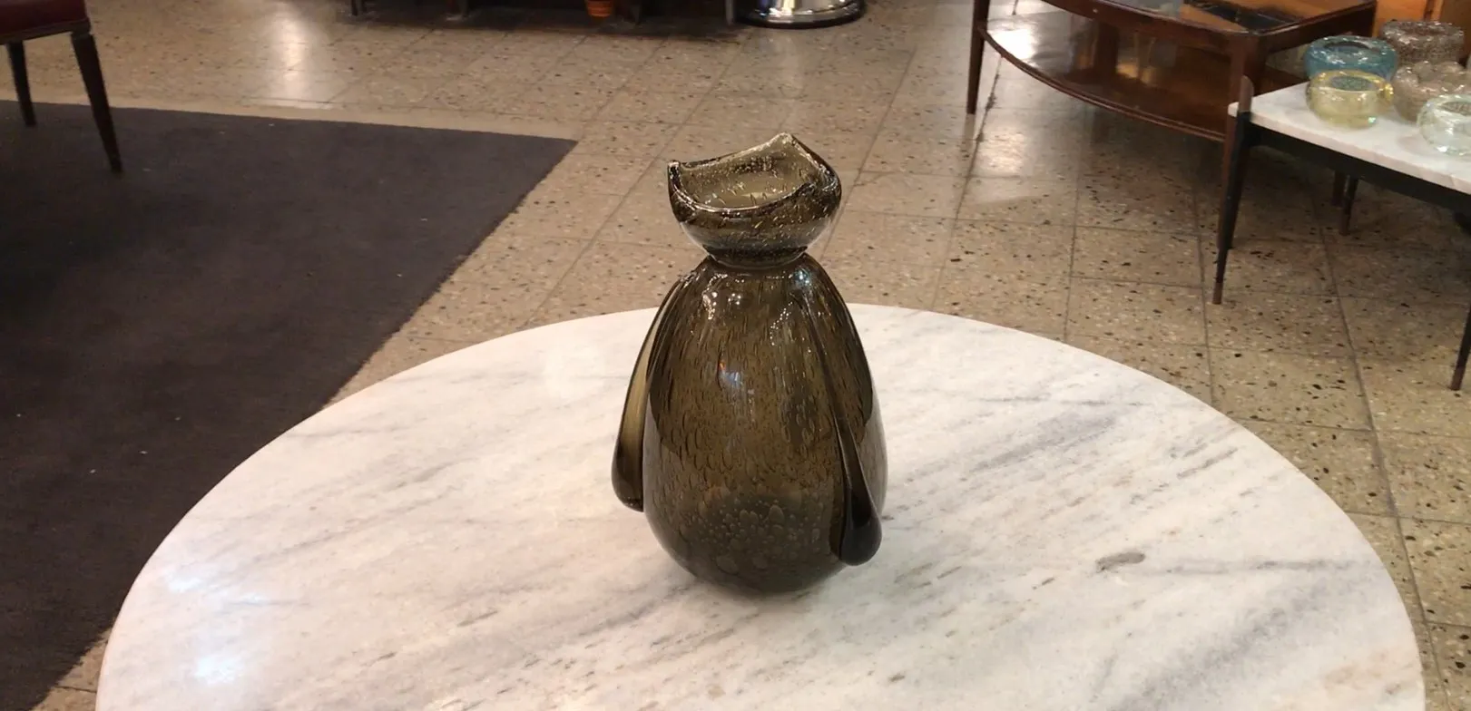 vidrio antiguo con firma, forma distintiva, fondo oscuro, ambiente elegante