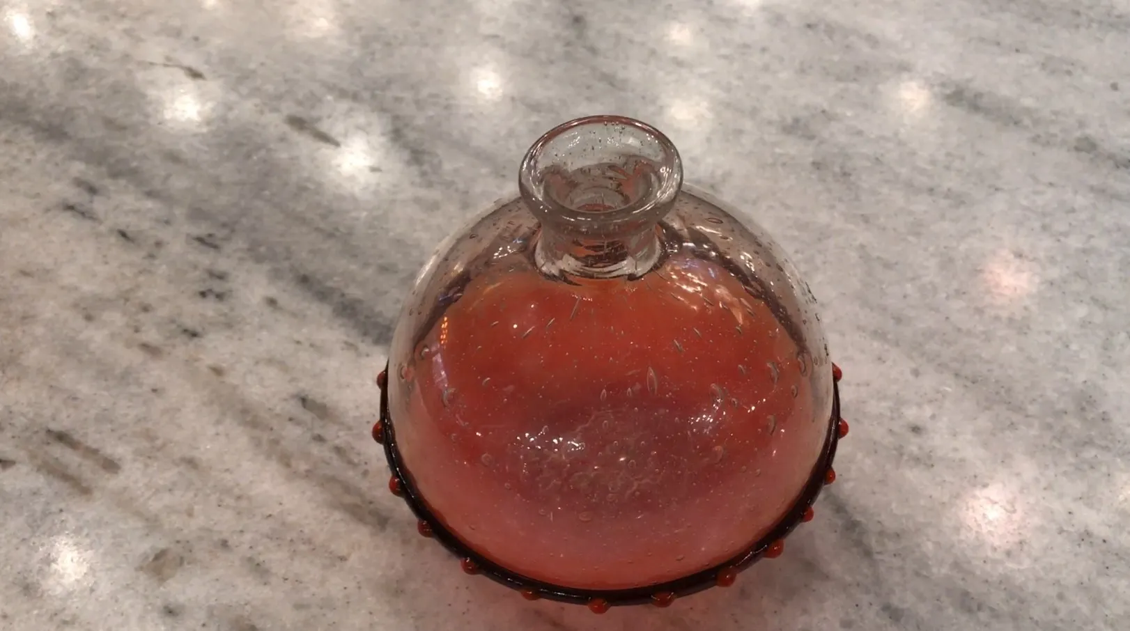 زجاج قديم موقّع من شندير بشكل متميز ولون مفعم بالحيوية، معروض على سطح رخام.