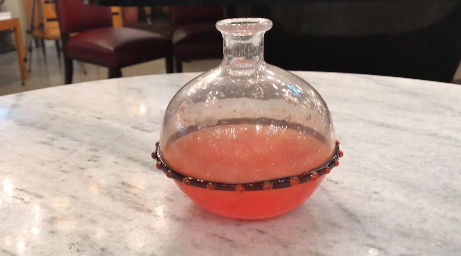 rounded signed glass with a colorful decorative band, on a table