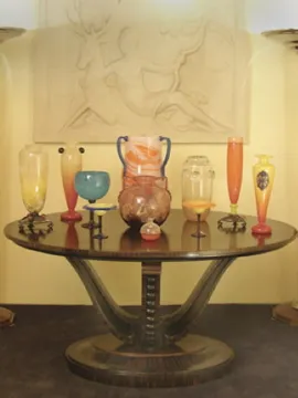 vintage dekoration mit signiertem glas in verschiedenen formen und farben auf einem tisch