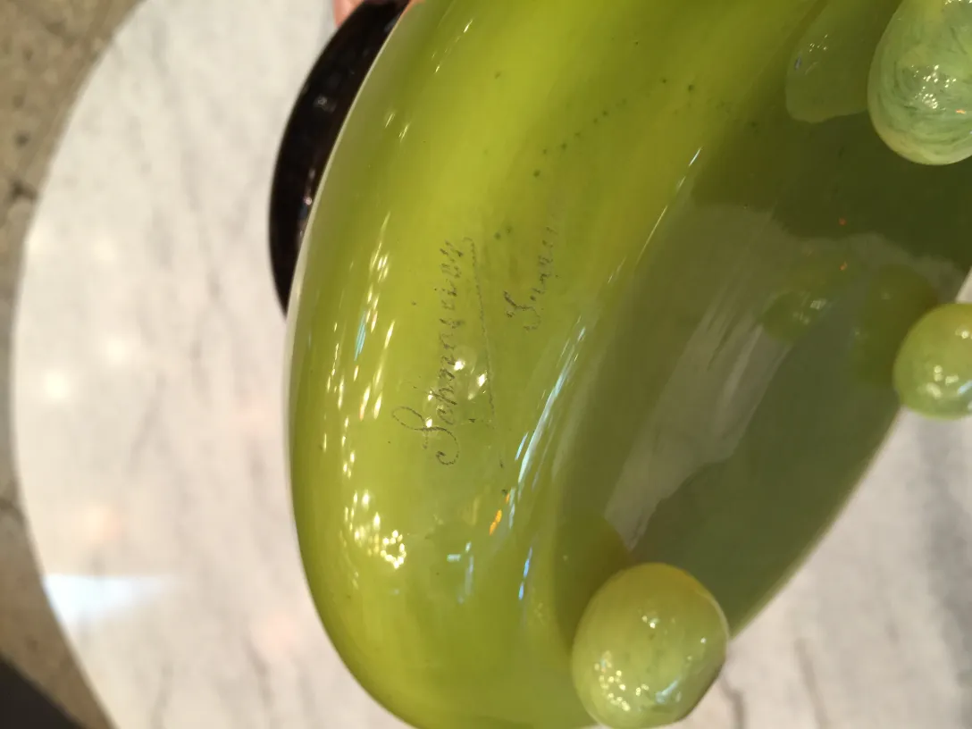 Vidrio firmado Schneider con detalle de firma en verde.