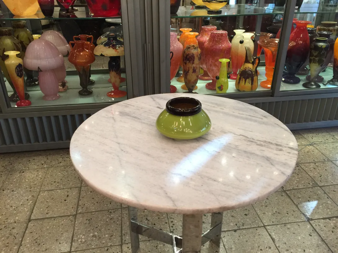 Verre signé Schneider sur table dans un environnement ancien.