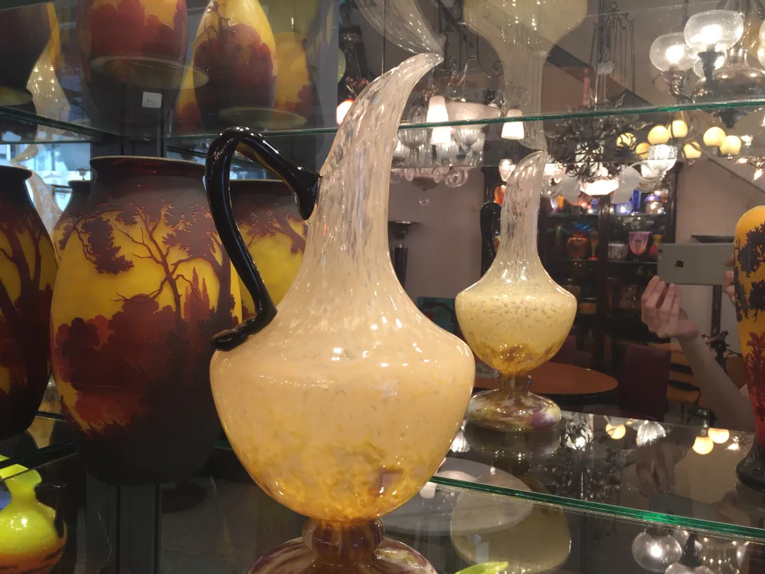 Glass jug with signature, antique style, decorative background.