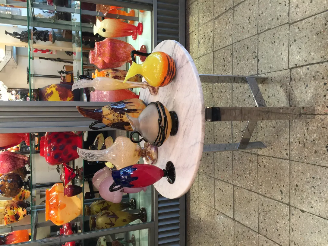 Vidrio firmado Schneider en una mesa con jarrones coloridos de fondo