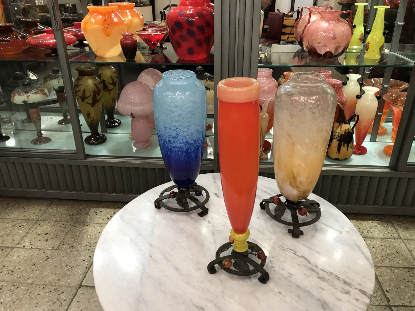 Three antique signed Schneider glass vases on display