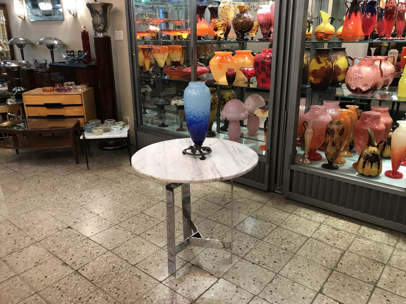 vidro assinado schneider em uma mesa pequena com detalhes coloridos ao fundo