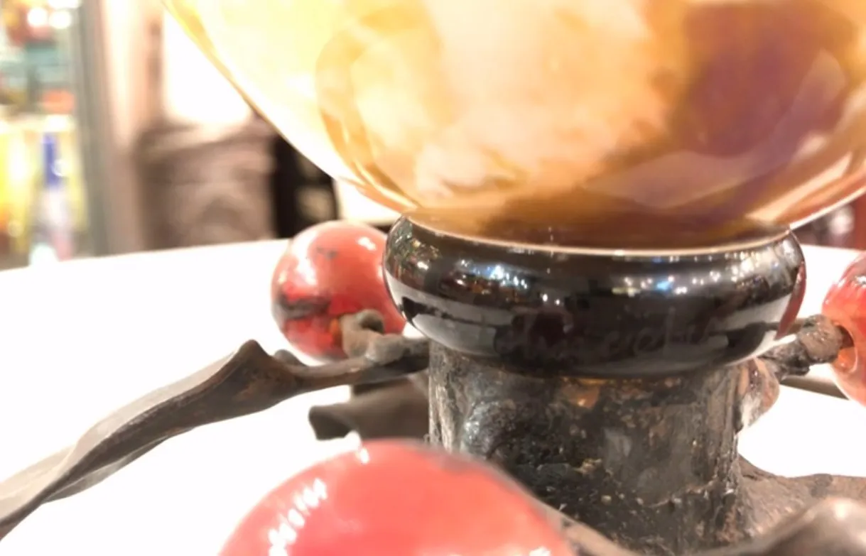 زجاج موقّع من شنايدر يُظهر تفاصيل زخرفية قديمة في الخلفية