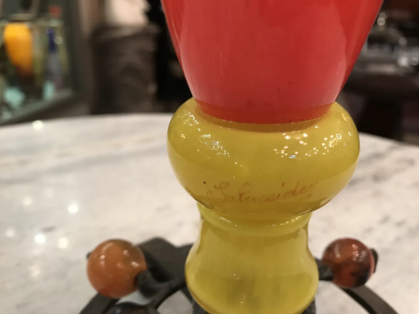 Detail of a signed Schneider glass, featuring vibrant colors in an antique setting